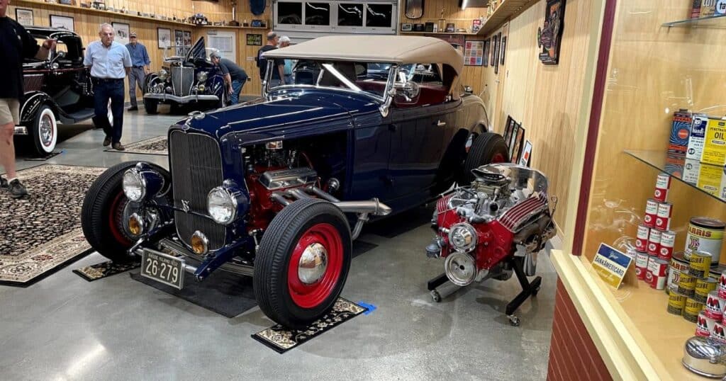 Classic cars displayed inside Piston Palace Museum with US Route 6 sign in Warwick Rhode Island